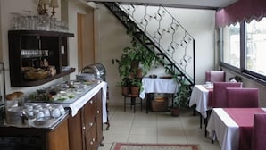 Una zona de menjador amb un sistema de buffet, una escala i plantes en testos.