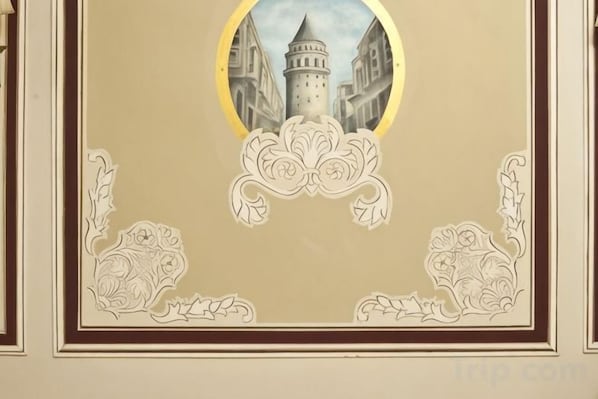 A framed architectural drawing with ornate floral designs and a central circular inset of a building. - Asmali Hotel (Istanbul)