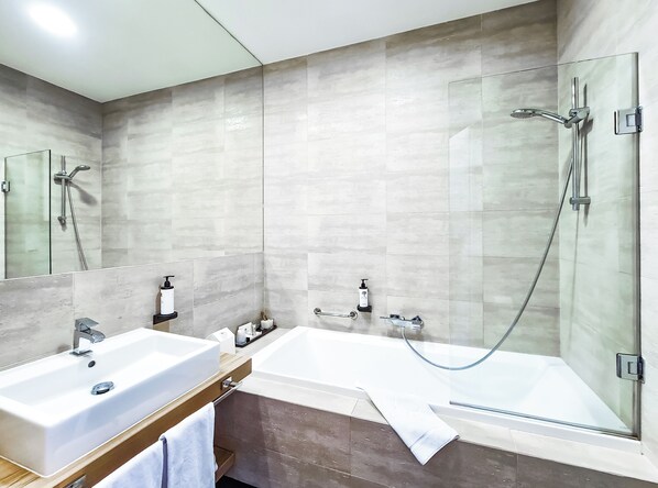 Un baño moderno con bañera, ducha y lavamanos.