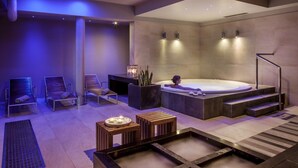 A modern spa with a hot tub, lounge chairs, and a small wooden table with candles. - Sielanka nad Pilicą (Warka)