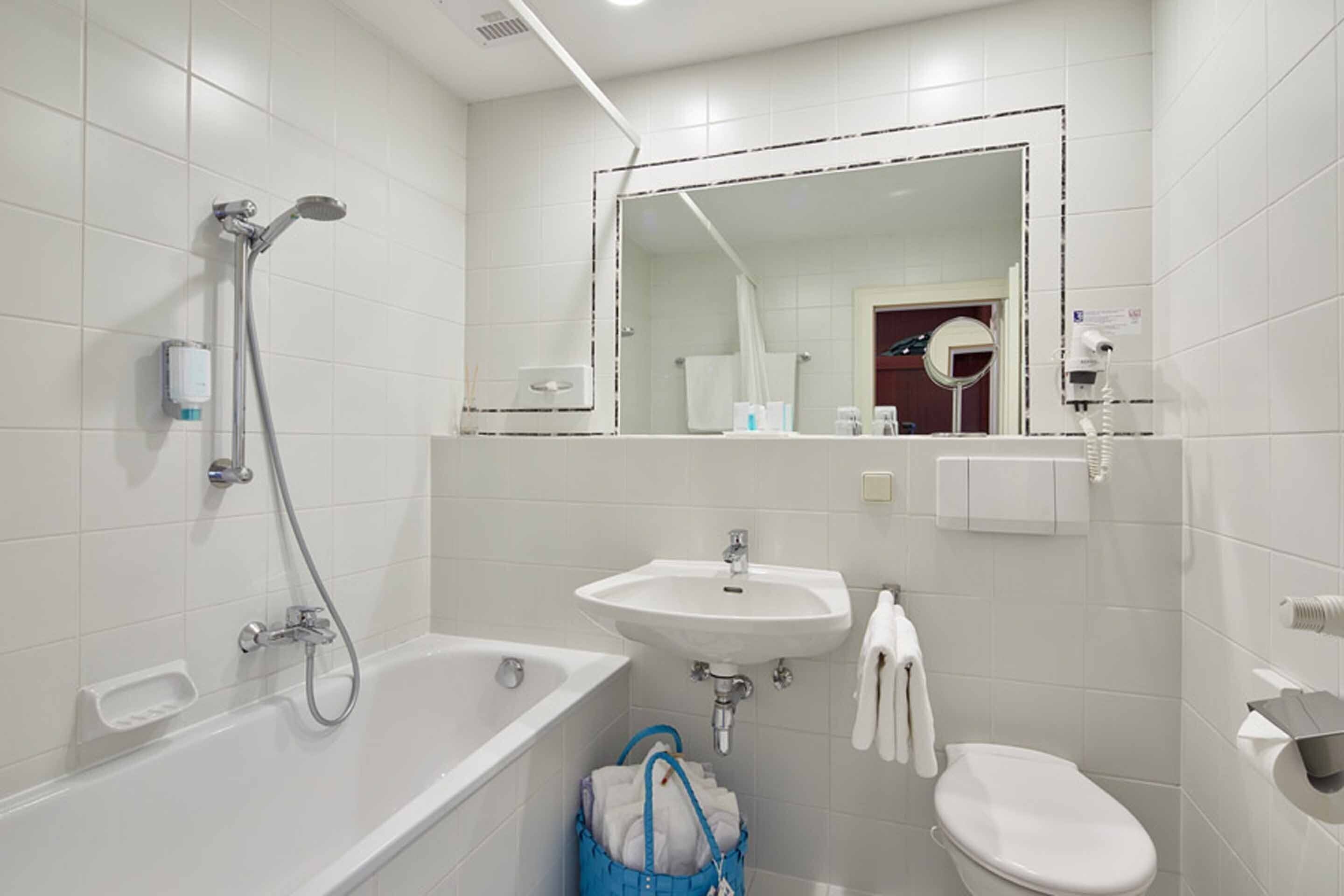 A modern bathroom with a bathtub, a sink, and a toilet.