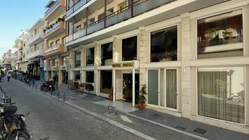A hotel with a modern facade, large windows, and balconies.