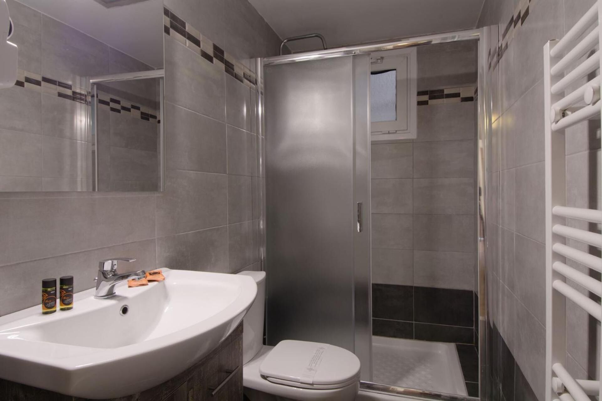 Ein modernes Badezimmer mit Waschbecken, Toilette und einer Duschkabine.