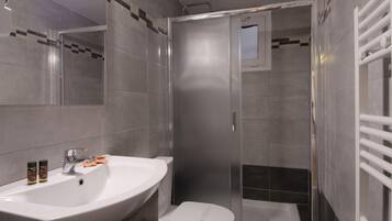 Ein modernes Badezimmer mit Waschbecken, Toilette und einer Duschkabine.