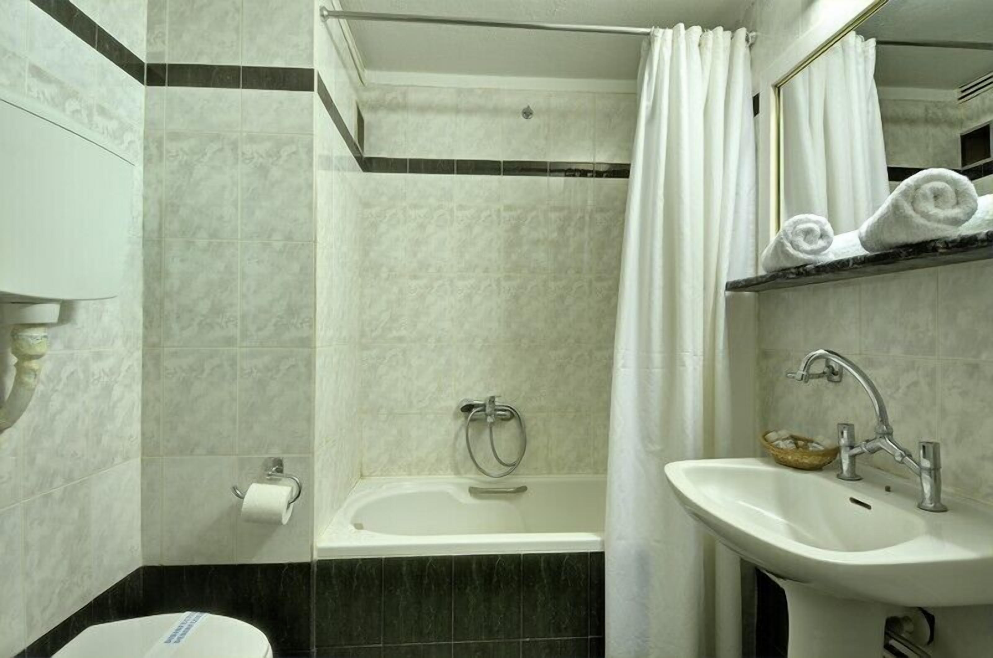 Un baño con bañera, lavabo e inodoro.