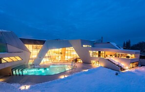 Un bâtiment moderne doté d’une piscine et entouré d’un paysage enneigé.