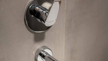 Un baño moderno con grifo cromado y lavamanos blanco.