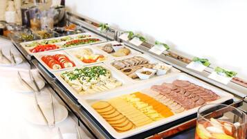 A buffet with various food items including sliced meats, cheeses, and vegetables.