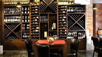 Una cava de vinos con estantes de madera y una mesa con sillas.