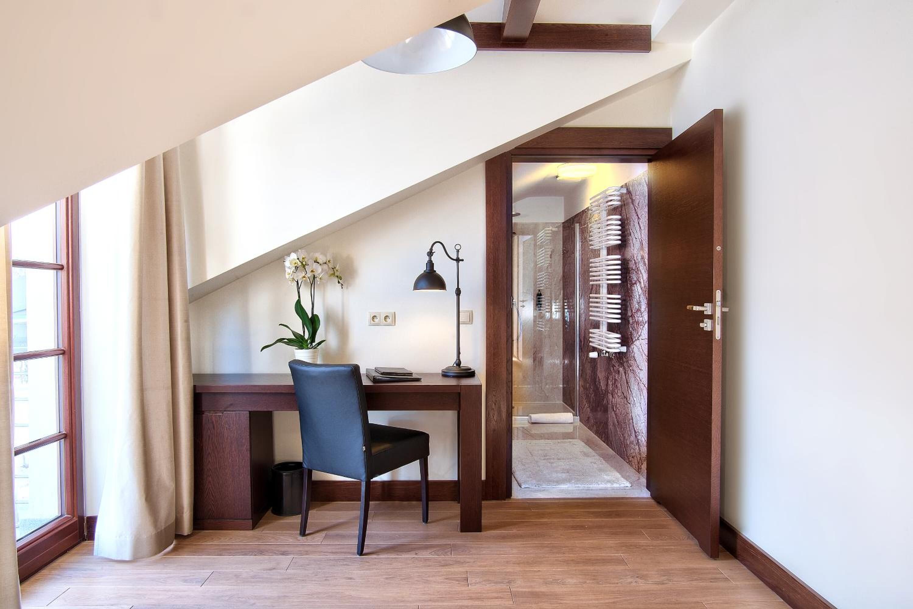 A modern room with a desk, chair, and a potted plant.