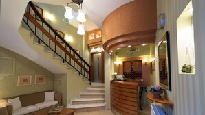 Ein großzügiger Wohnbereich mit Treppe, einer Rezeption und einer Sitzecke.
