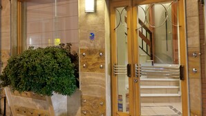 Ein Hotel mit Eingangsbereich, einer Treppe und einem Blumentopf.
