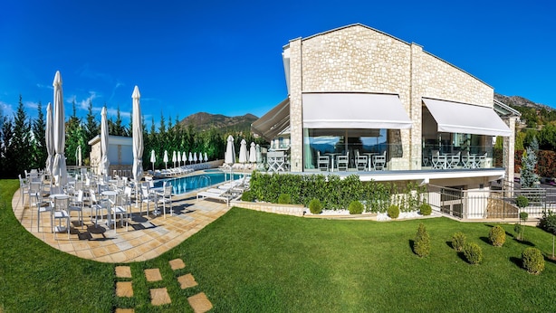 Un edificio moderno con piscina, zona de estar exterior y césped bien cuidado.