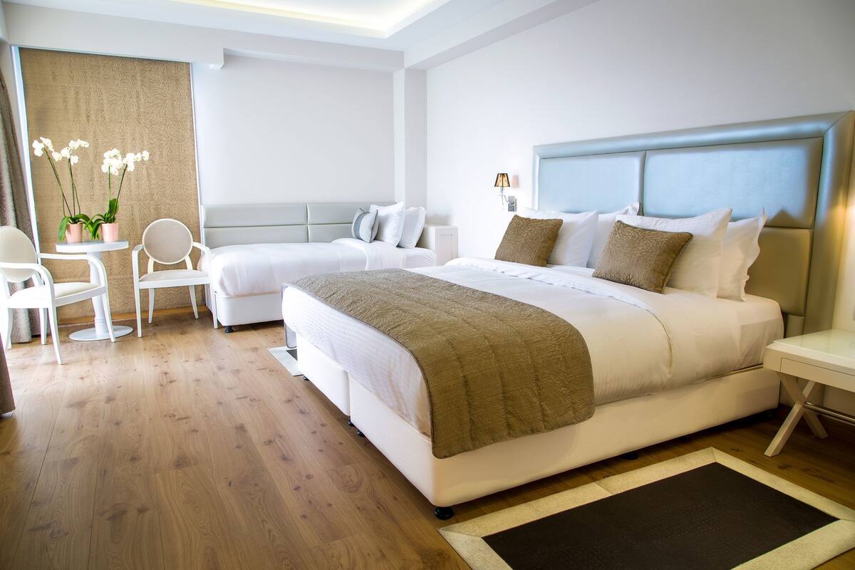 Una habitación de hotel moderna con una cama grande, un escritorio y una silla.