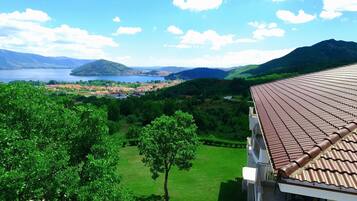 Blick auf eine Stadt mit einem See, Bergen und einem Gebäude mit einem Ziegeldach.