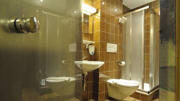 A modern bathroom with a glass shower enclosure, a sink, and a toilet.