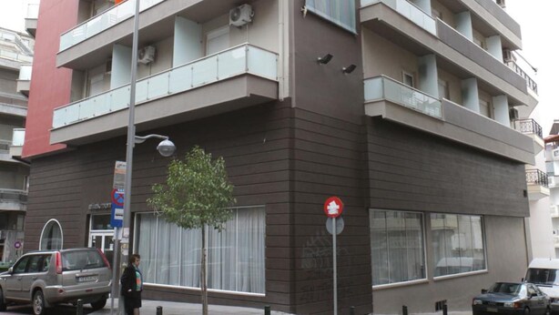 A multi-story building with balconies, a visible sign, and a street view. - Aliakmon Hotel (Kozani)