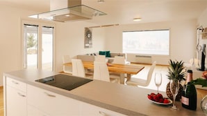 A modern kitchen with a built-in oven, microwave, and a large island with a sink.