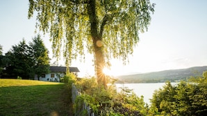 A house with a view of a lake and hills in the background.