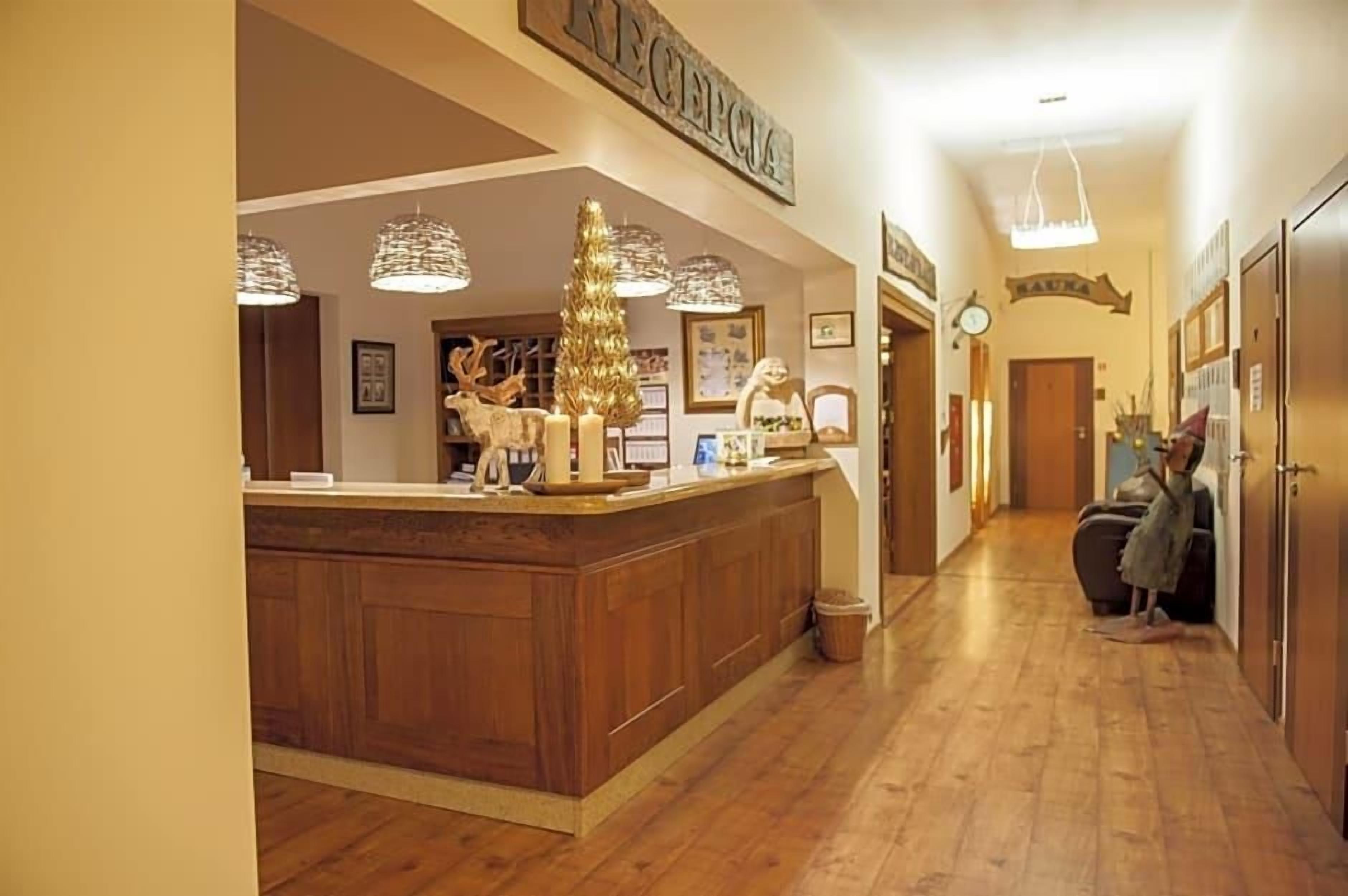 A reception area with a wooden counter, a Christmas tree, and a sign that reads 'RECEPTION.'