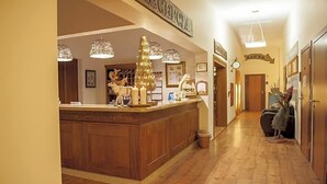 A reception area with a wooden counter, a Christmas tree, and a sign that reads 'RECEPTION.' - Na Skarpie (Chojnice)
