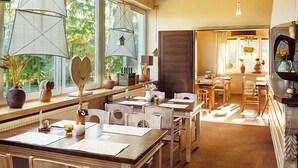 A hotel room with a dining area, large windows, and a fireplace. - Na Skarpie (Chojnice)