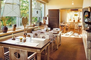 A hotel room with a dining area, large windows, and a fireplace. - Na Skarpie (Chojnice)