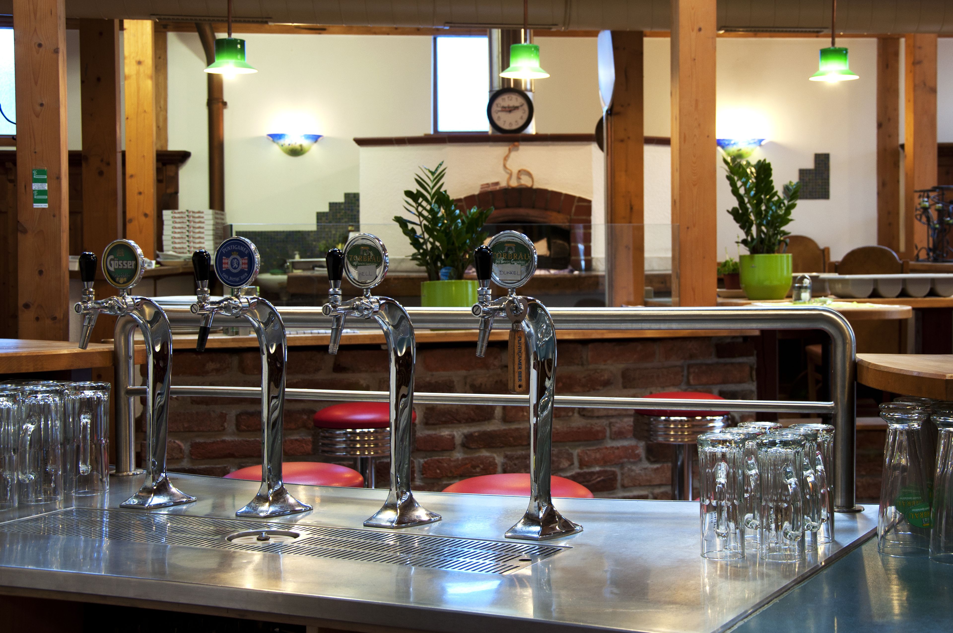 A bar area with multiple taps and glasses.