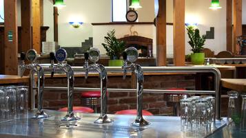 A bar area with multiple taps and glasses.
