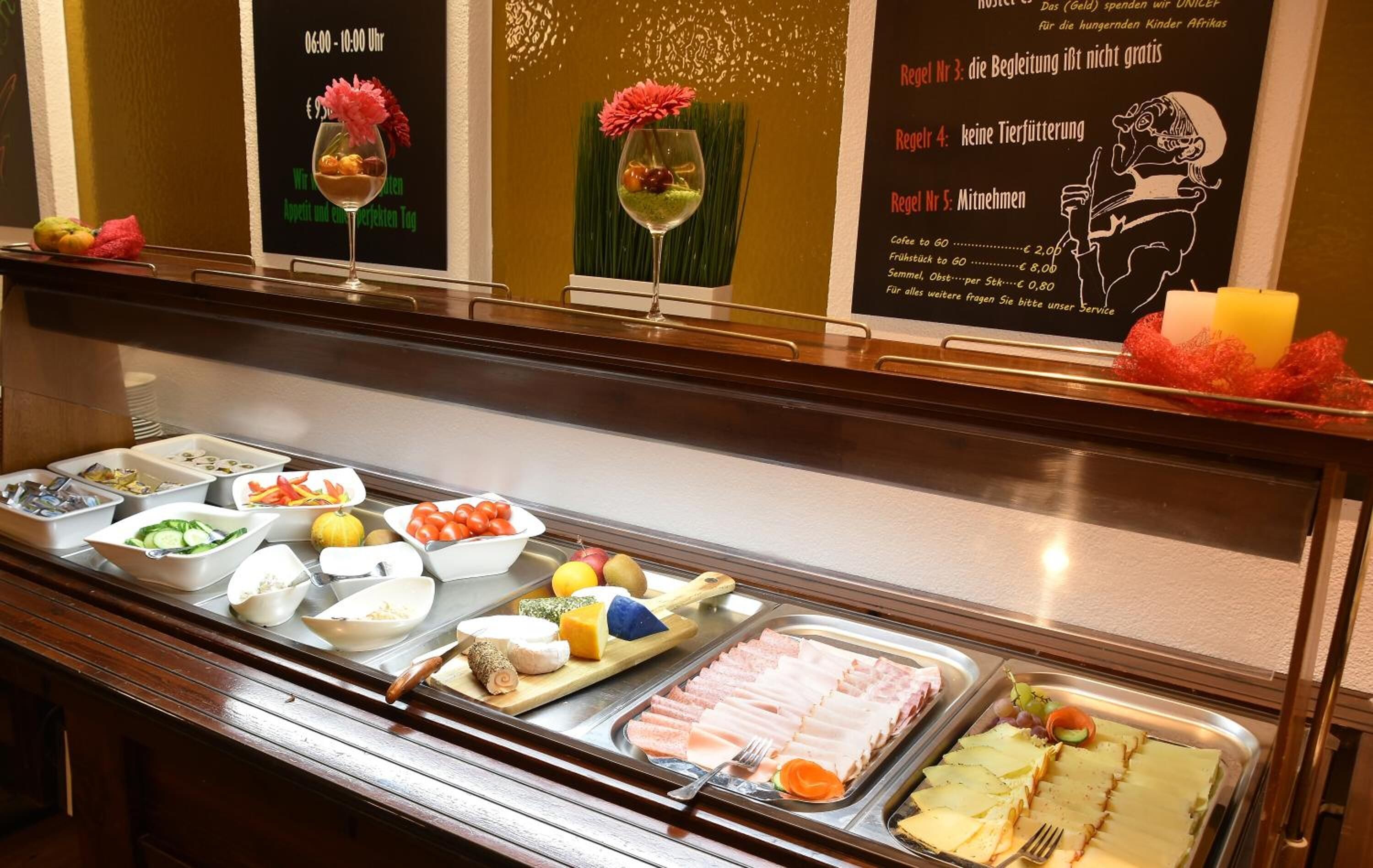 A buffet with various food items including fruits, vegetables, and meats.