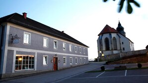 A two-story building with a red door and multiple windows. - Gasthof Alpenblick (Ardagger Markt)