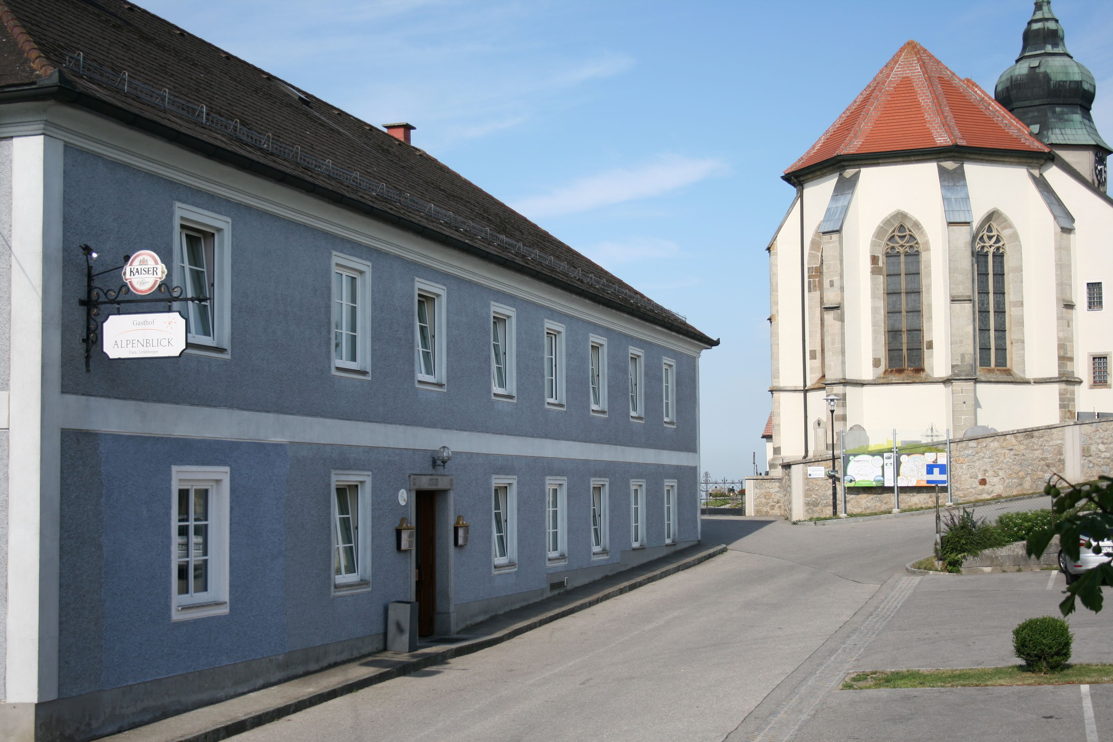 A two-story building with a blue facade and a red-roofed tower.