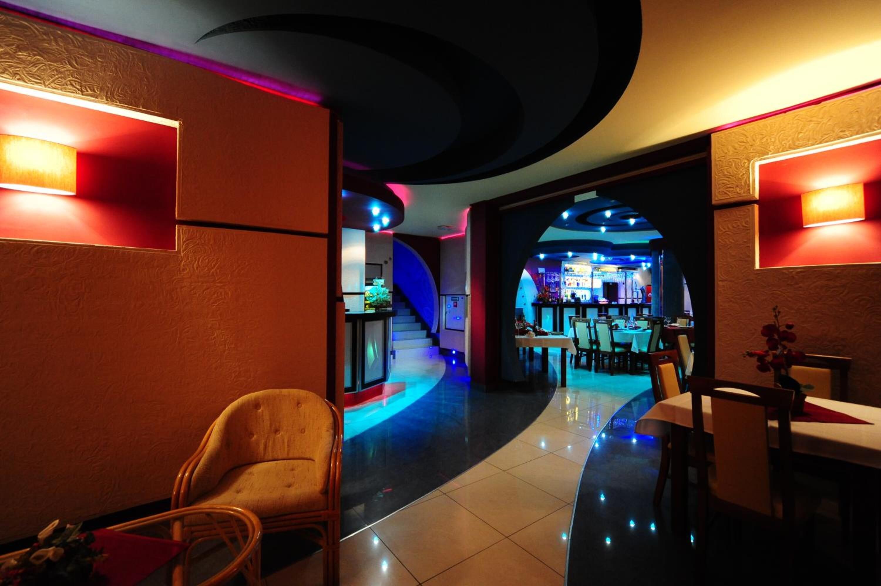 A hotel lobby with a curved ceiling, a bar area, and seating arrangements.