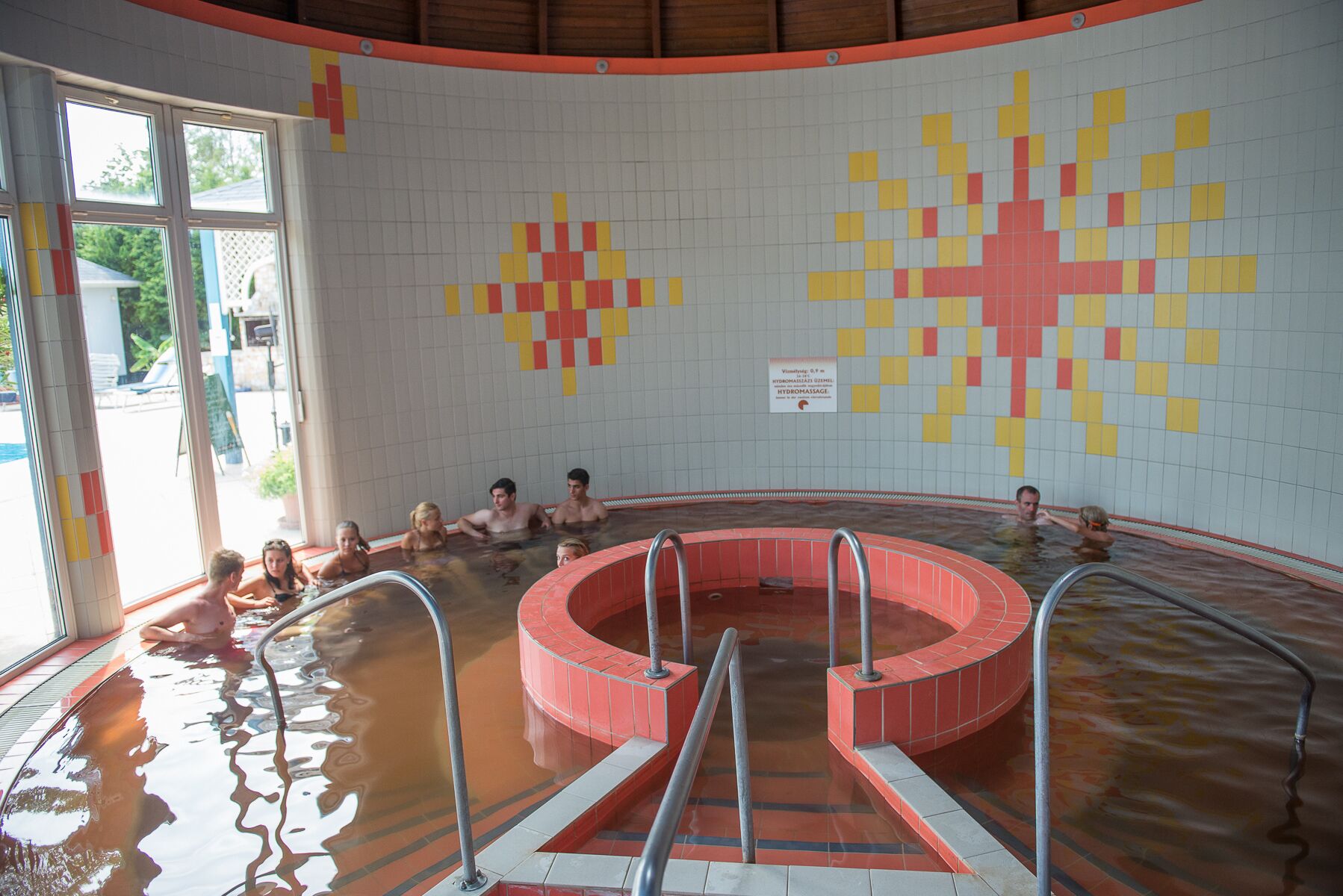 A swimming pool with a tiled wall featuring a geometric pattern.