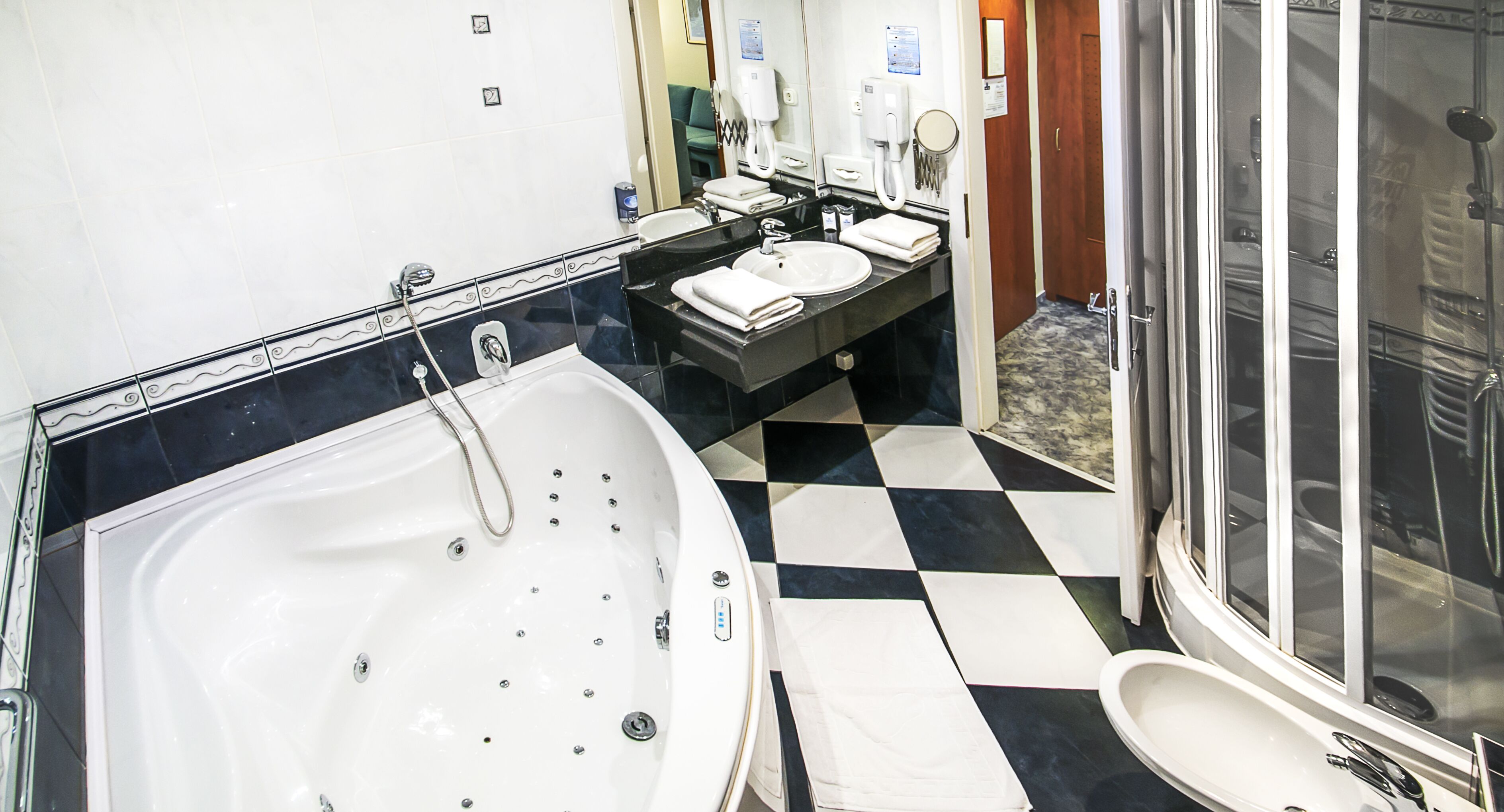 A modern bathroom with a large bathtub, a separate shower area, and a vanity with a sink and mirror.