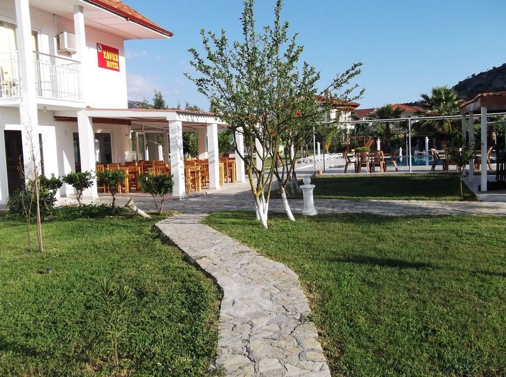Um hotel com área de estar coberta ao ar livre, piscina e caminho de pedra.