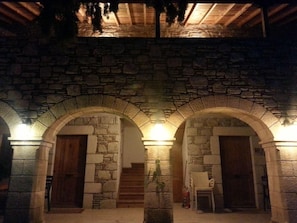 Un edificio in pietra con portali ad arco e una scala che conduce a un piano superiore.