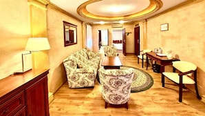 Amplia sala de estar con sofá, sillón y mesa de comedor con sillas.