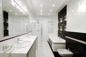 Une salle de bain moderne avec deux lavabos, une douche et un bidet.