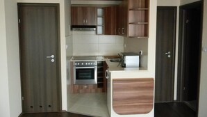 Una cocina funcional con armarios de madera, estufa y microondas.