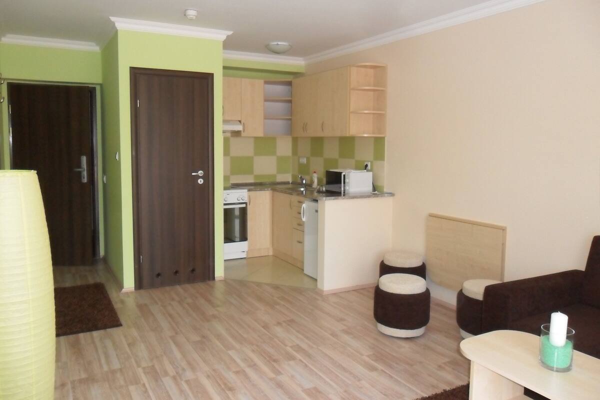 A compact living space with a kitchenette, a dining area, and a seating area.