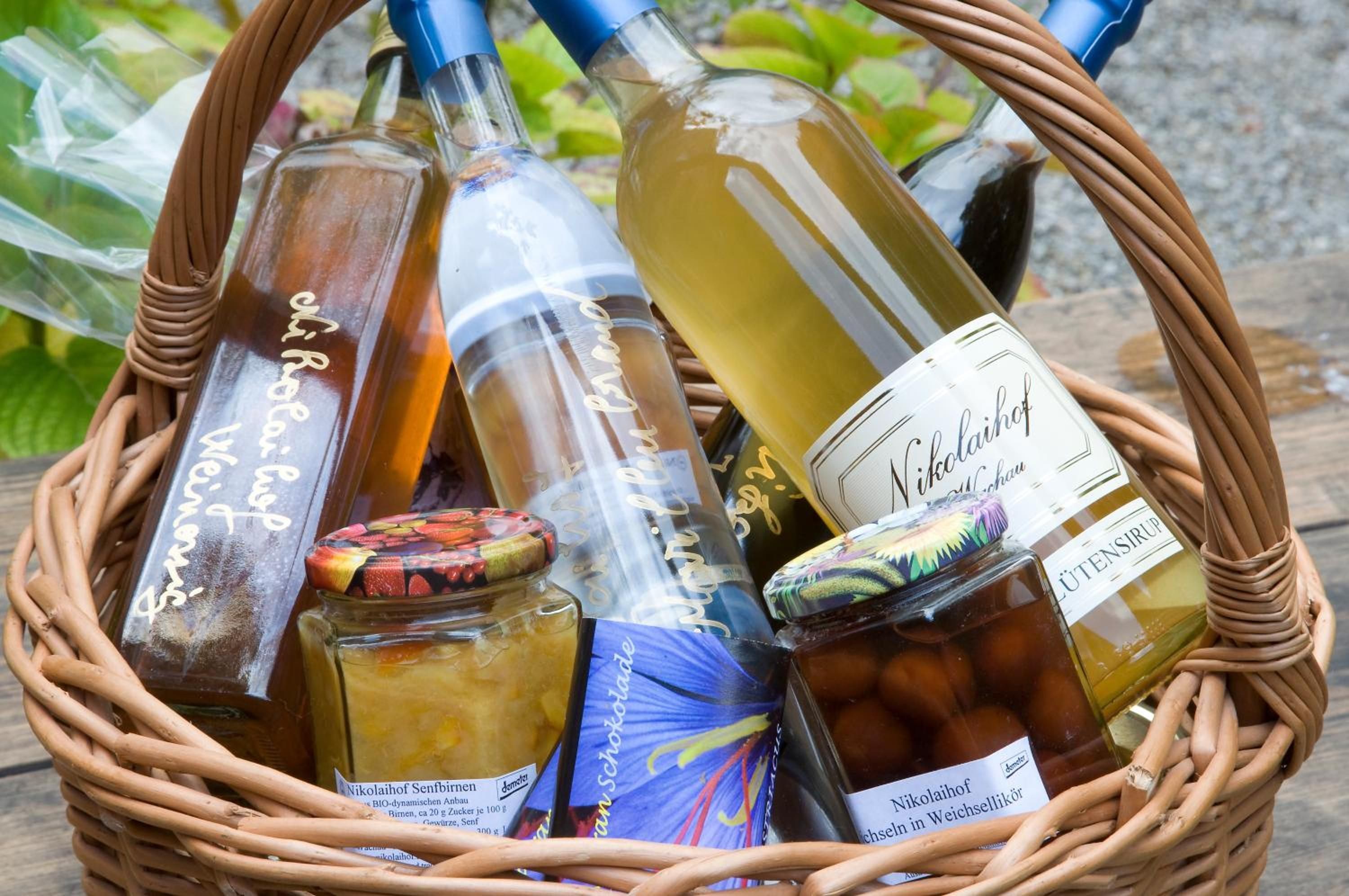 Una cesta de mimbre con varias botellas y frascos, probablemente con alimentos o salsas.