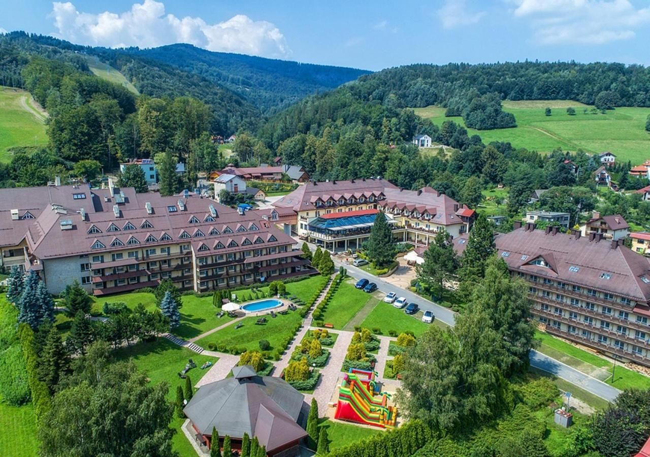 Un complejo hotelero con varias construcciones, piscina y parque infantil.