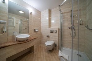 A modern bathroom with a large mirror, a sink, a toilet, and a shower area. - Hotel Stok (Wisla)