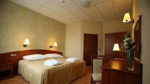 A hotel room with a bed, bedside lamps, a desk with a mirror, and a chair. - Hotel Zawiercie (Zawiercie)