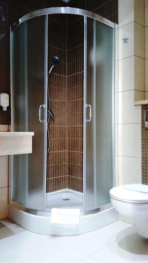 Un baño moderno con ducha envuelta en vidrio, inodoro y lavamanos.
