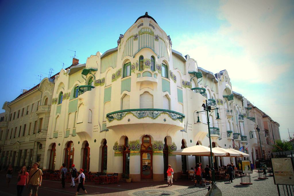 Ein historisches Gebäude mit aufwendiger Architektur, das eine geschwungene Fassade und mehrere Balkone zeigt.