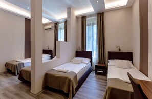 A hotel room with three single beds, a large mirror, an air conditioning unit, and a view of the city through the window. - Vén Diófa De Lux Panzió (Szeged)