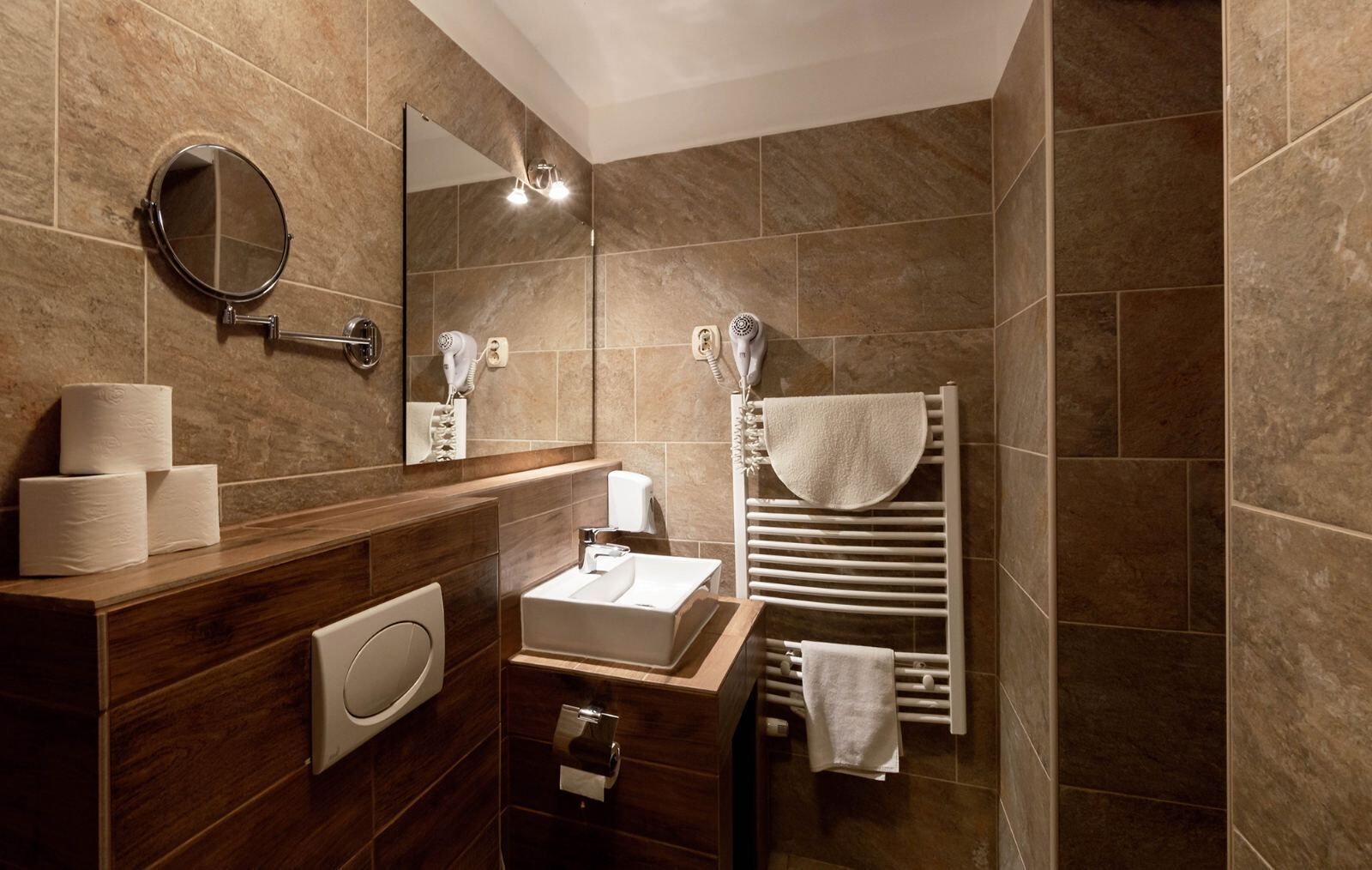A modern bathroom with a wooden vanity, a sink, a mirror, and a towel rack.