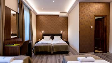 A hotel room with two beds, a desk, a chair, and a large mirror.